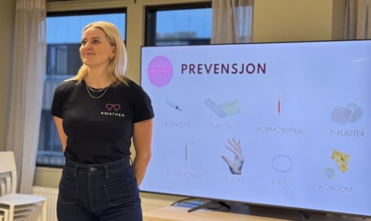 Kvinne står foran skjerm med prevensjonsinformasjon